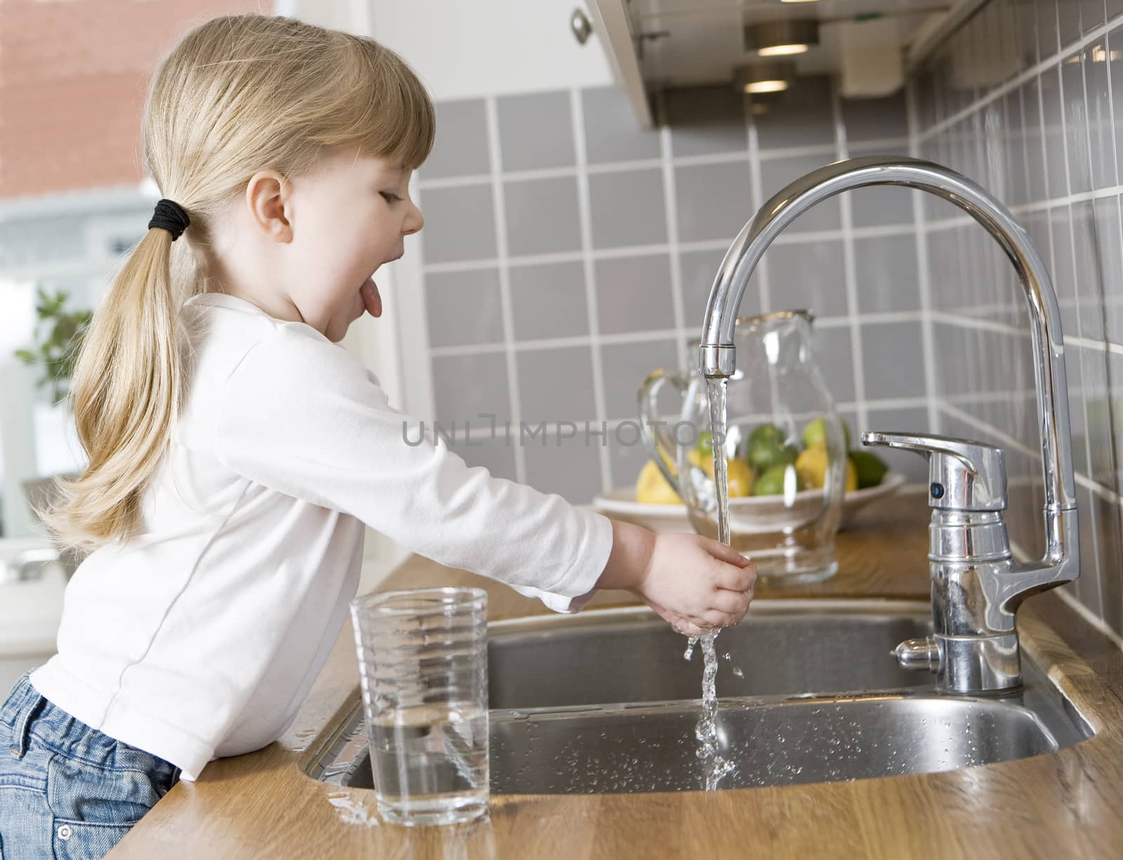 Small Girl in the kitchen drinking water