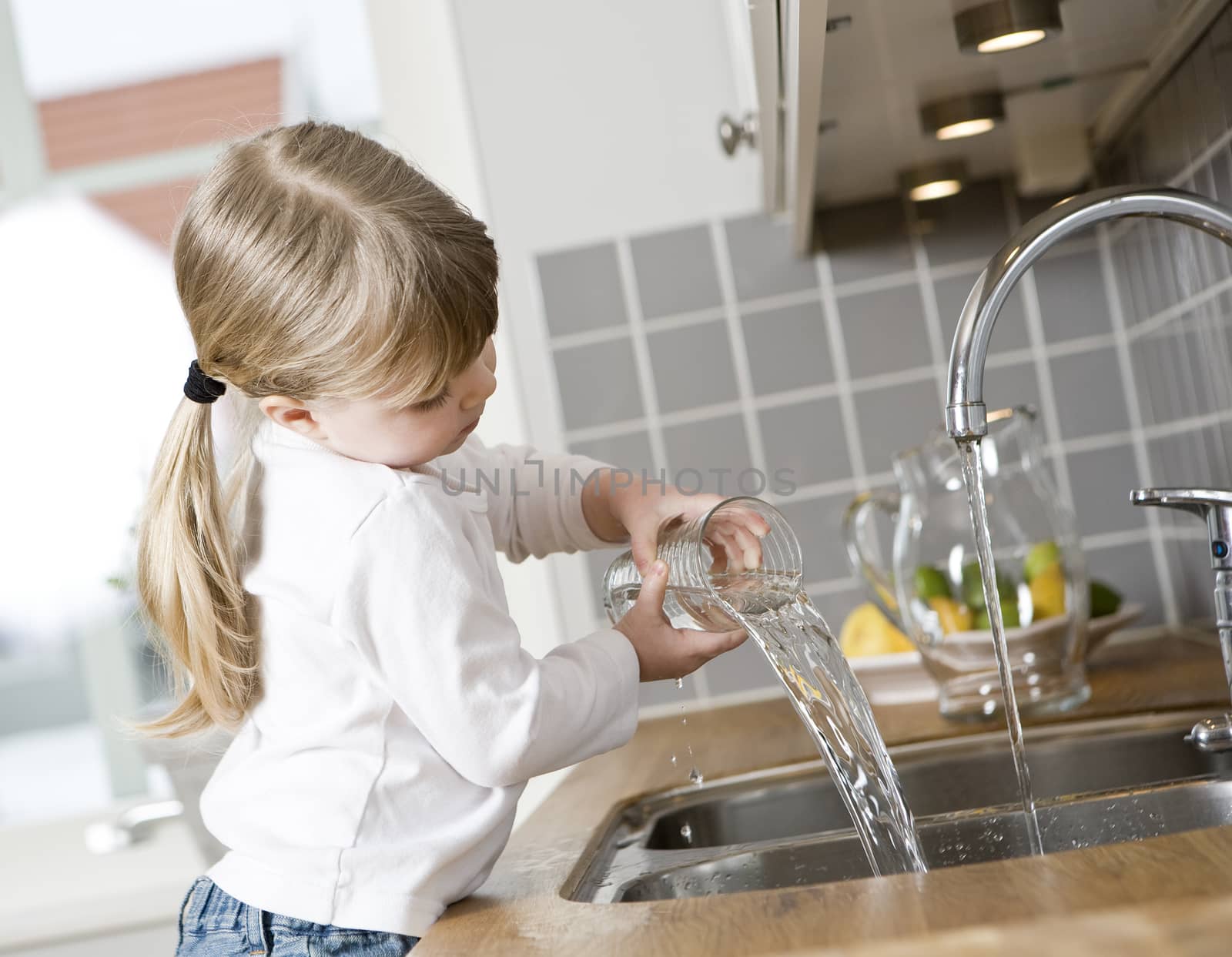 Small Girl in the kitchen drinking water