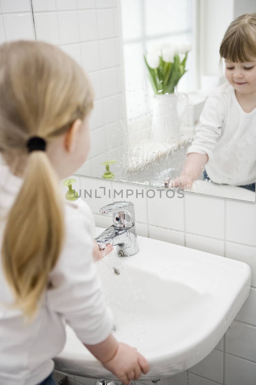 Small Girl washing hands in the bathroom
