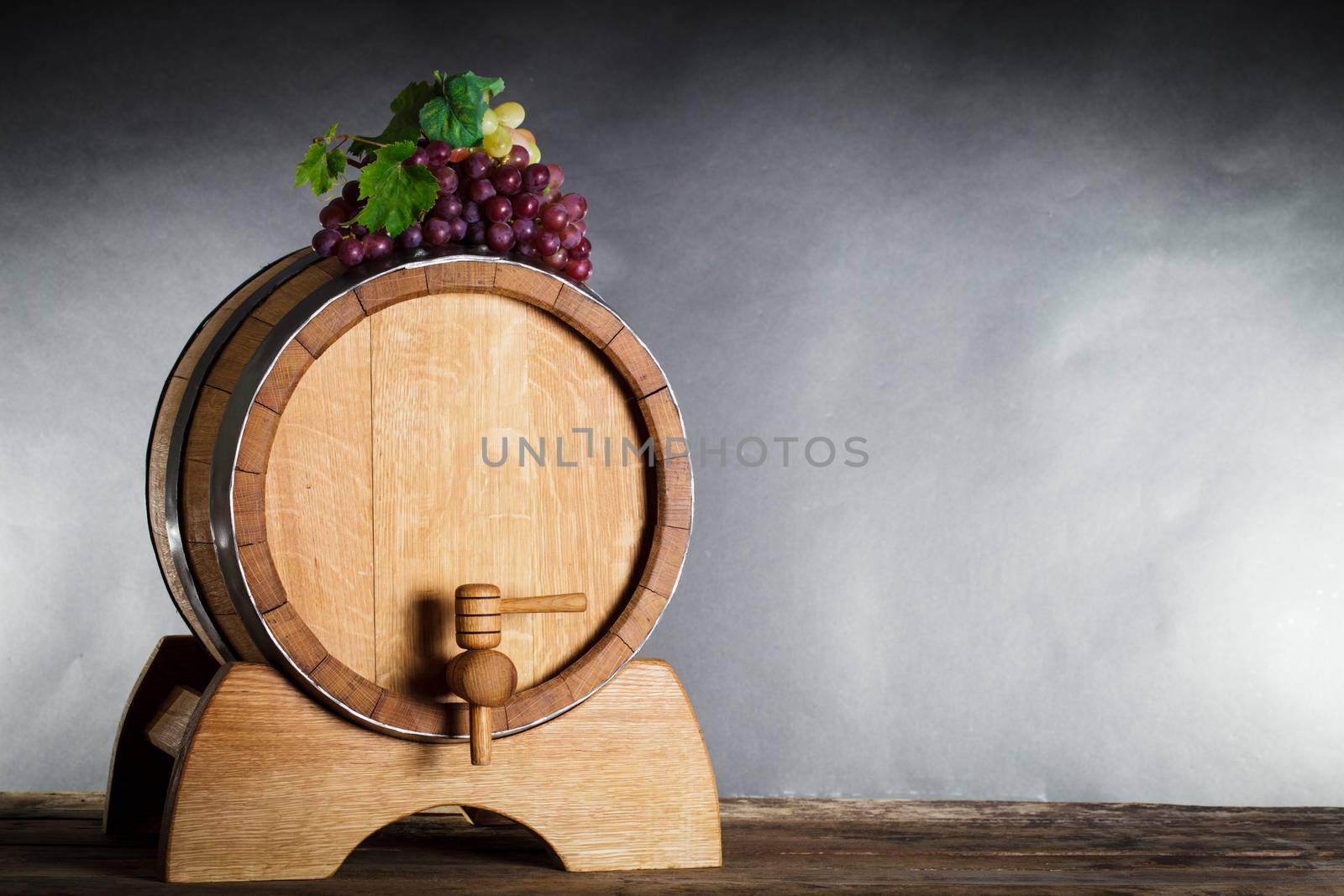 Grapes on wooden barrel with wine and copy space