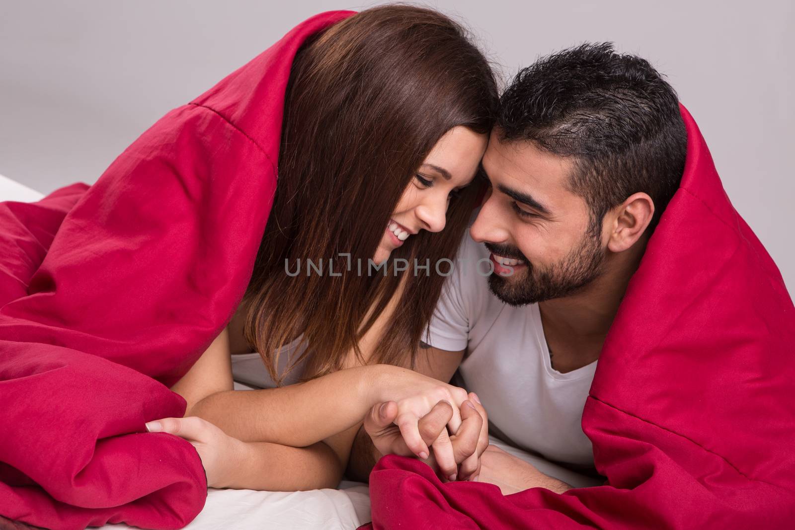 Young love couple relaxing together in bed 