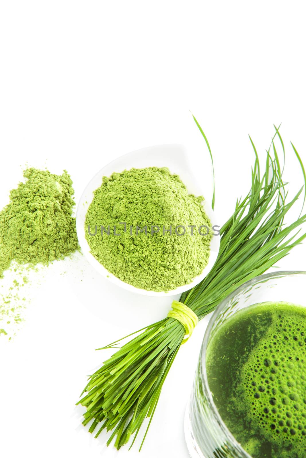 Herbal medicine. Organic wheat grass powder, barley grass blades and green juice isolated on white background. Healthy living, fitness lifestyle.