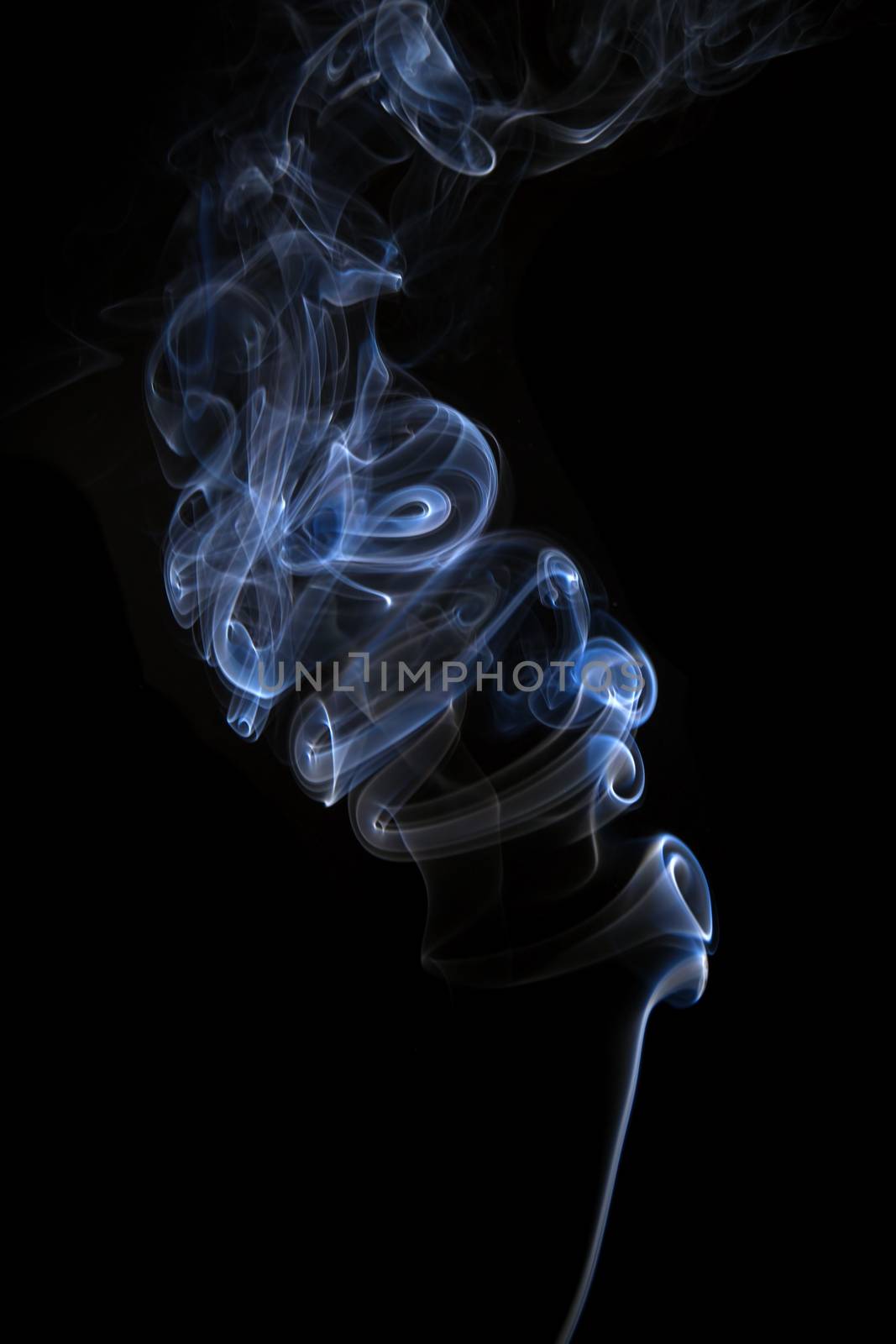 Blue smoke swirl isolated on black. Abstract background.