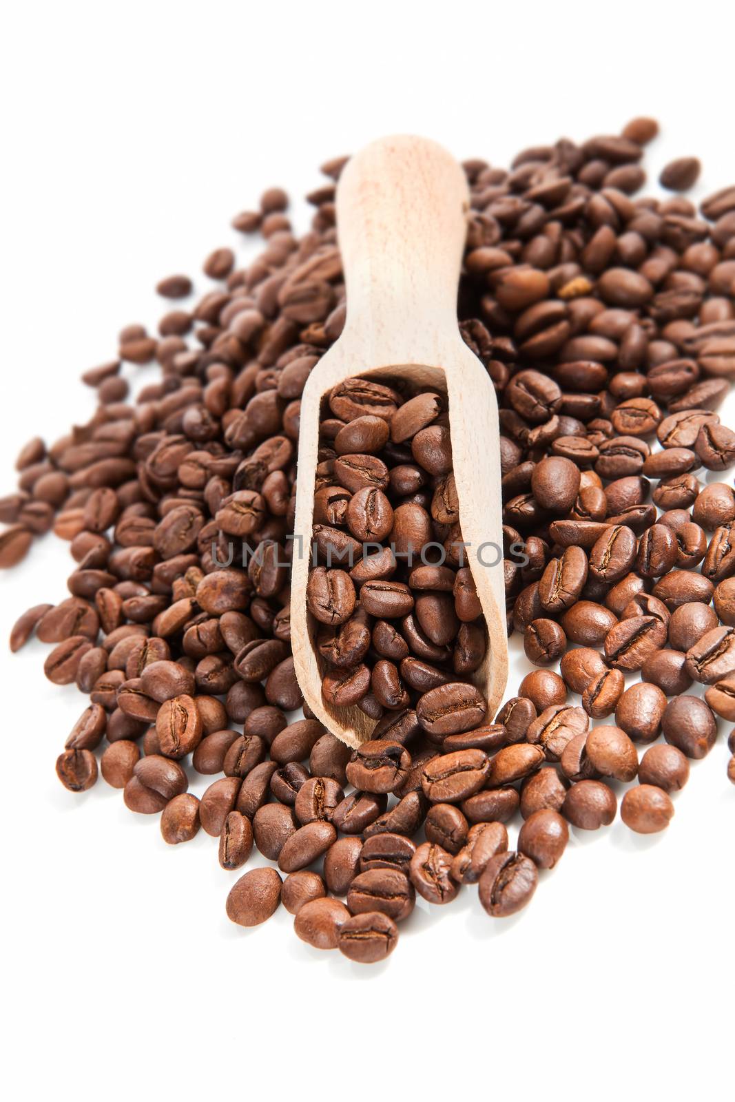 Pile of coffee beans and coffee beans on wooden scoop isolated on white background. Traditional coffee background.