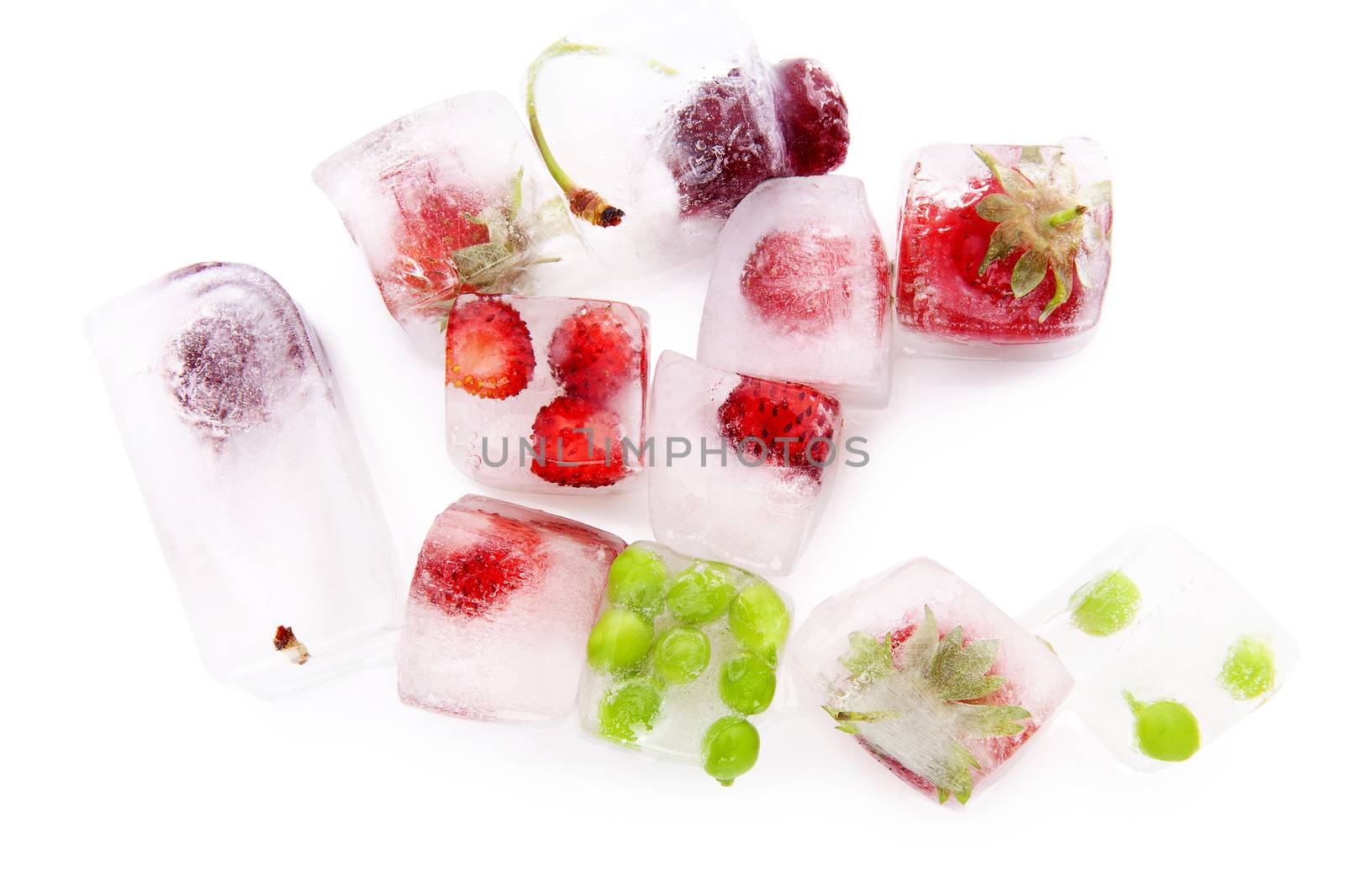 Fresh delicious summer fruit and vegetable frozen in ice cubes isolated on white, top view. Strawberries, cherries and green peas.