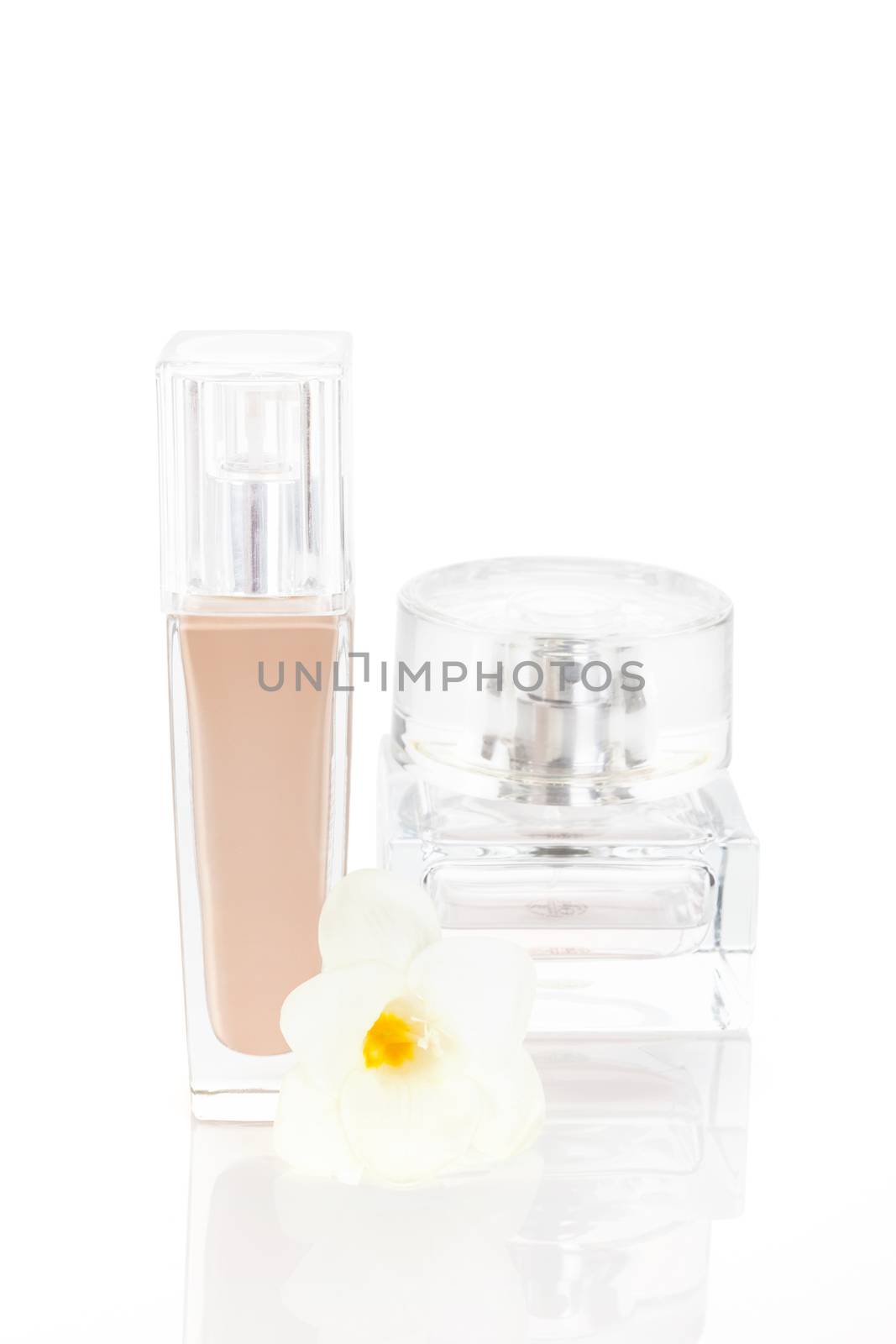 Still life of various cosmetics. Make up and lotion isolated on white background with flower. Feminine beauty concept.