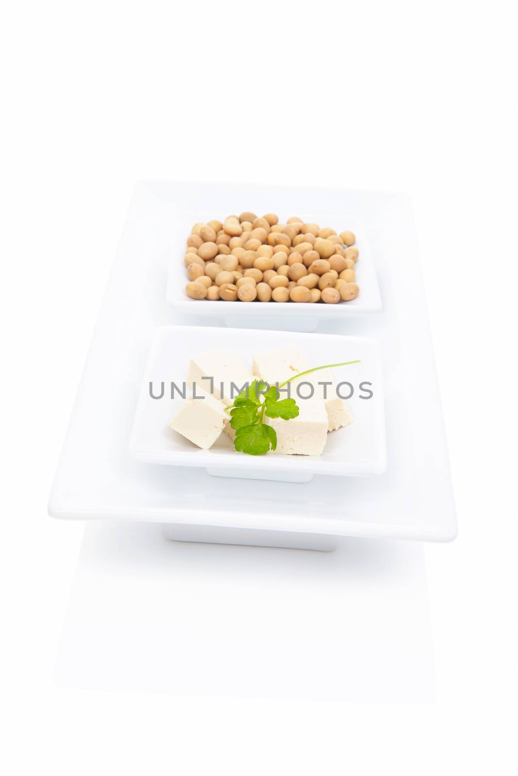 Tofu with green herbs and soybeans in white square bowl isolated on white background. Vegetarian & vegan eating. 