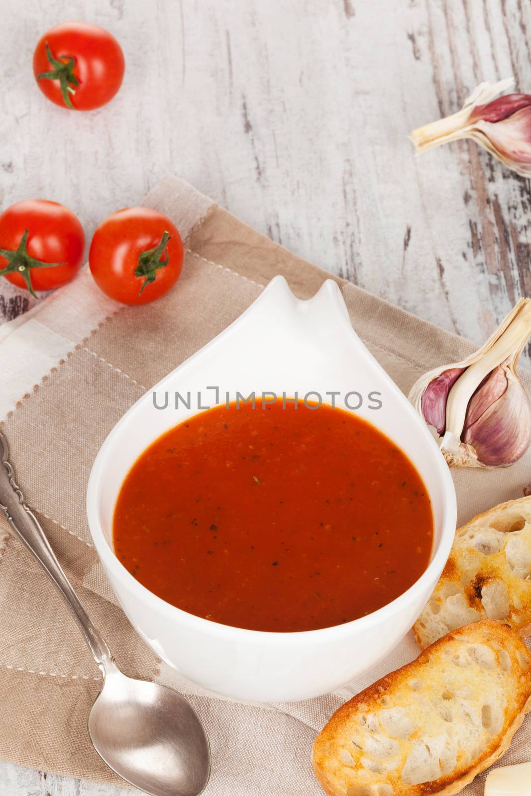 Delicious tomato soup background with toasted baguette, tomatoes and garlic. Culinary healthy delicious vegetarian eating.