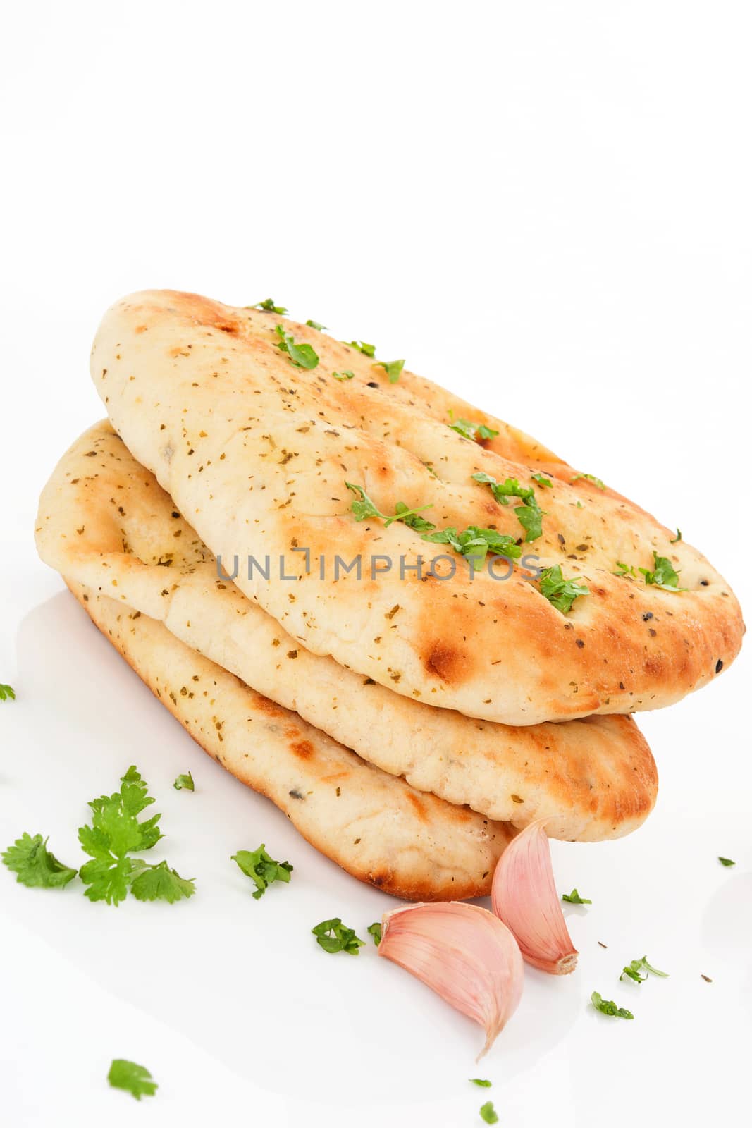 Delicious garlic and coriander naan flatbread with fresh herbs and garlic isolated on white background. Culinary eat asian cuisine.