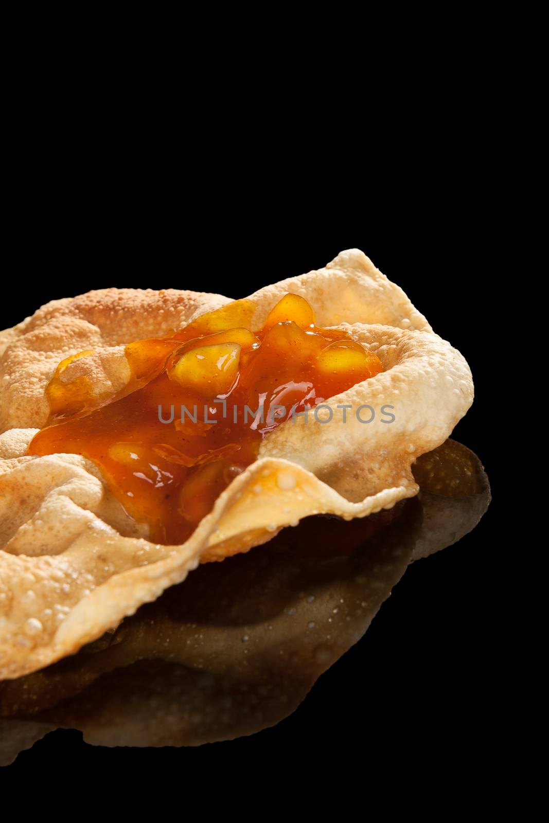 Pappadum with chutney isolated on black background with reflection. Luxurious culinary indian eating concept.