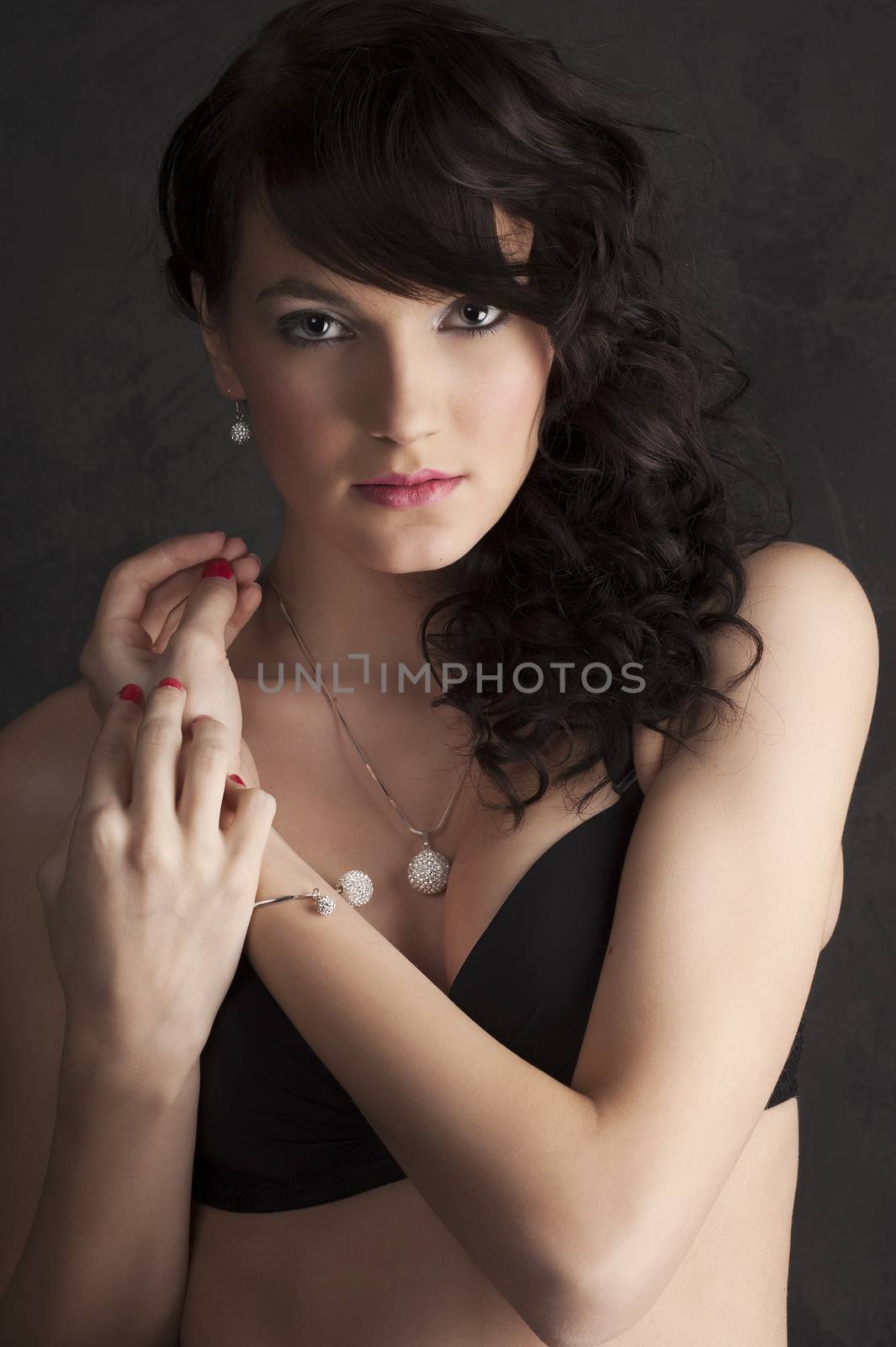 close up portrait of a brunette with make up and hair style in black bra and red lips