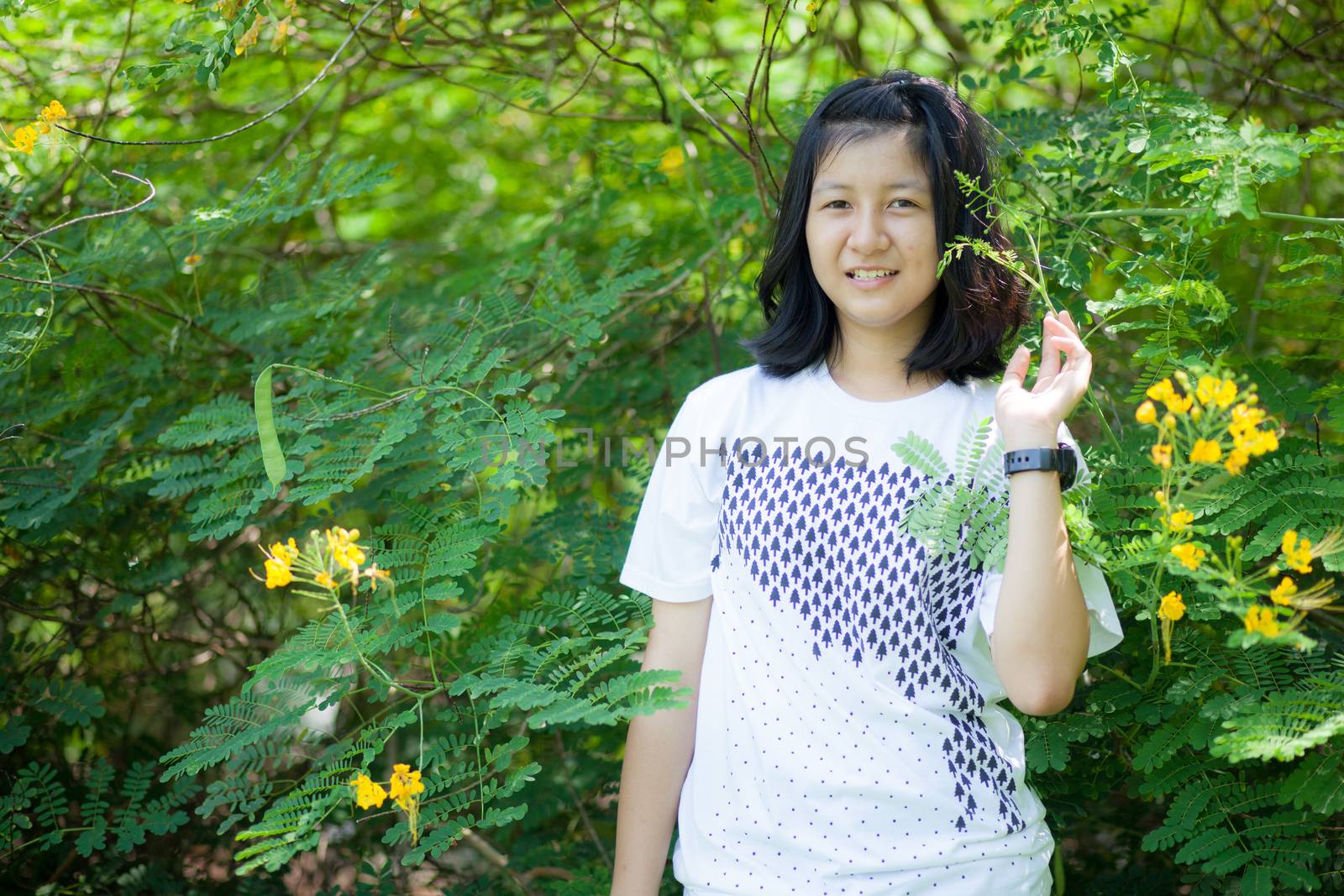 asian girl and yellow flower in park.actie smile and relax.