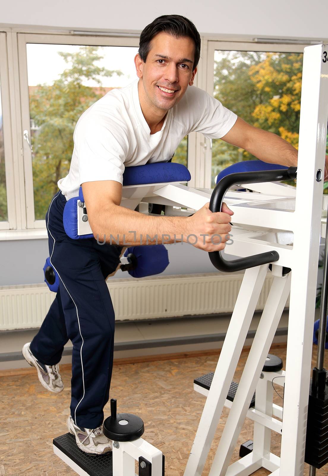 Athletic man exercising and lifting weights in a fitness center