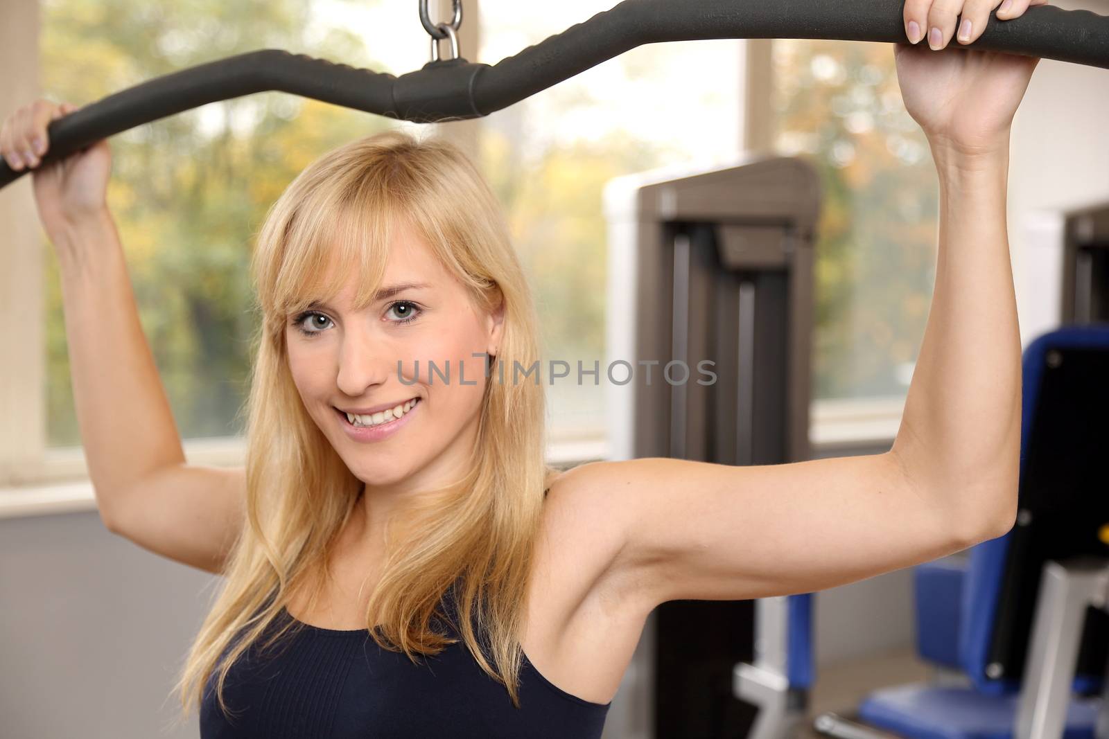 Attractive blonde woman weightlifting in a gym by ikonoklast_fotografie