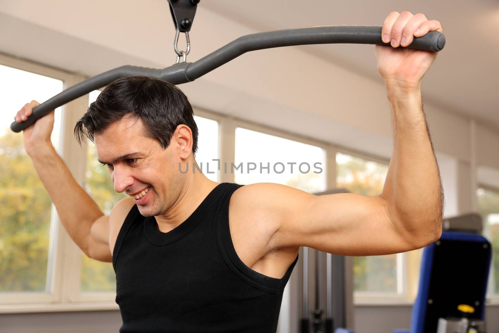Athletic man exercising and lifting weights in a fitness center