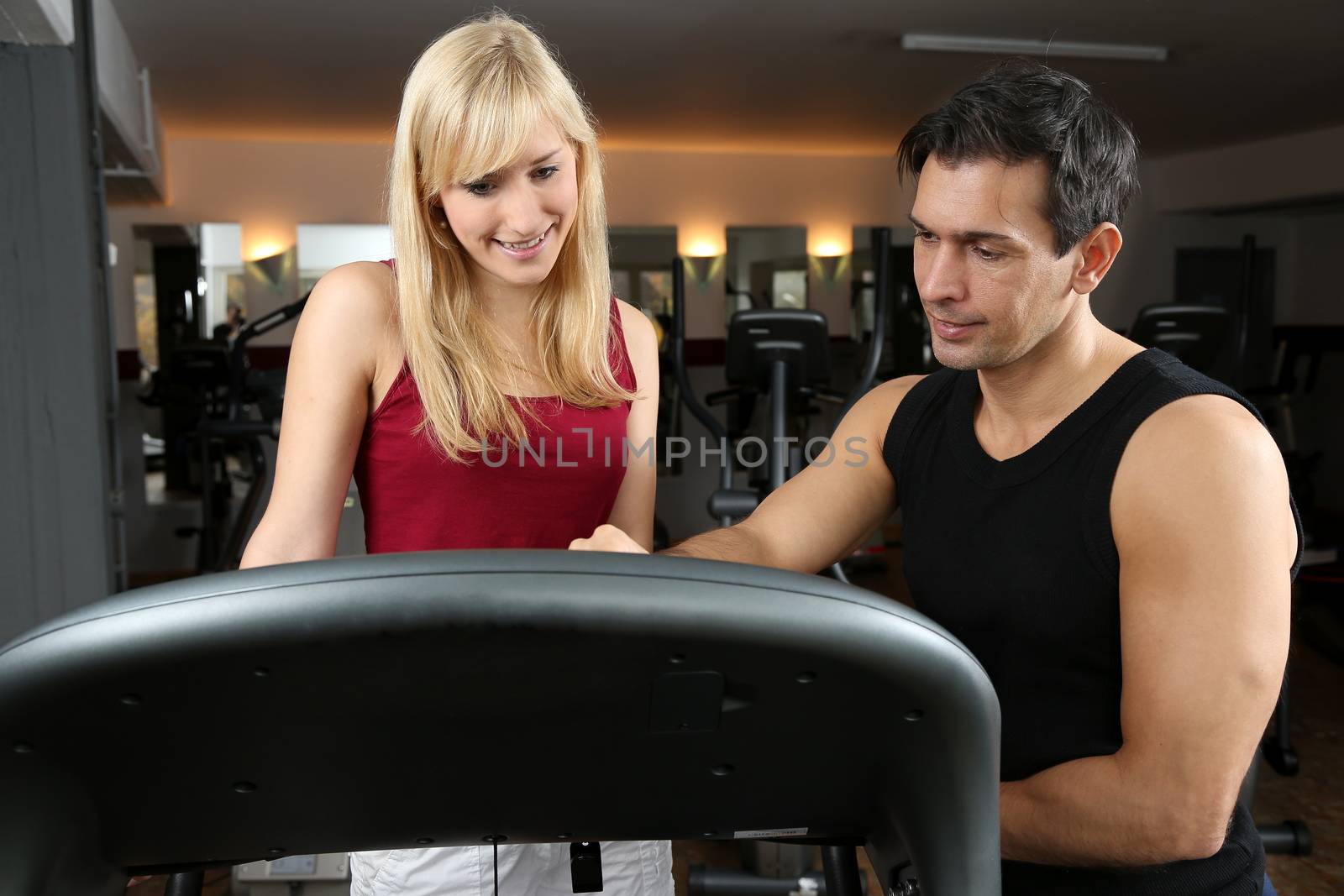 Personal trainer and athletic woman working out in a fitness center