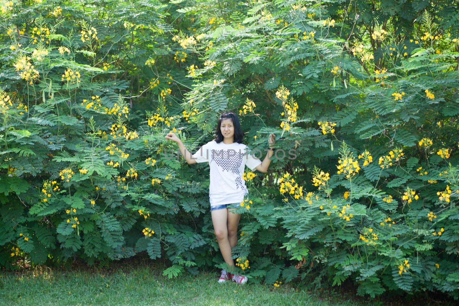 asian girl and yellow flower in park.actie smile and relax.