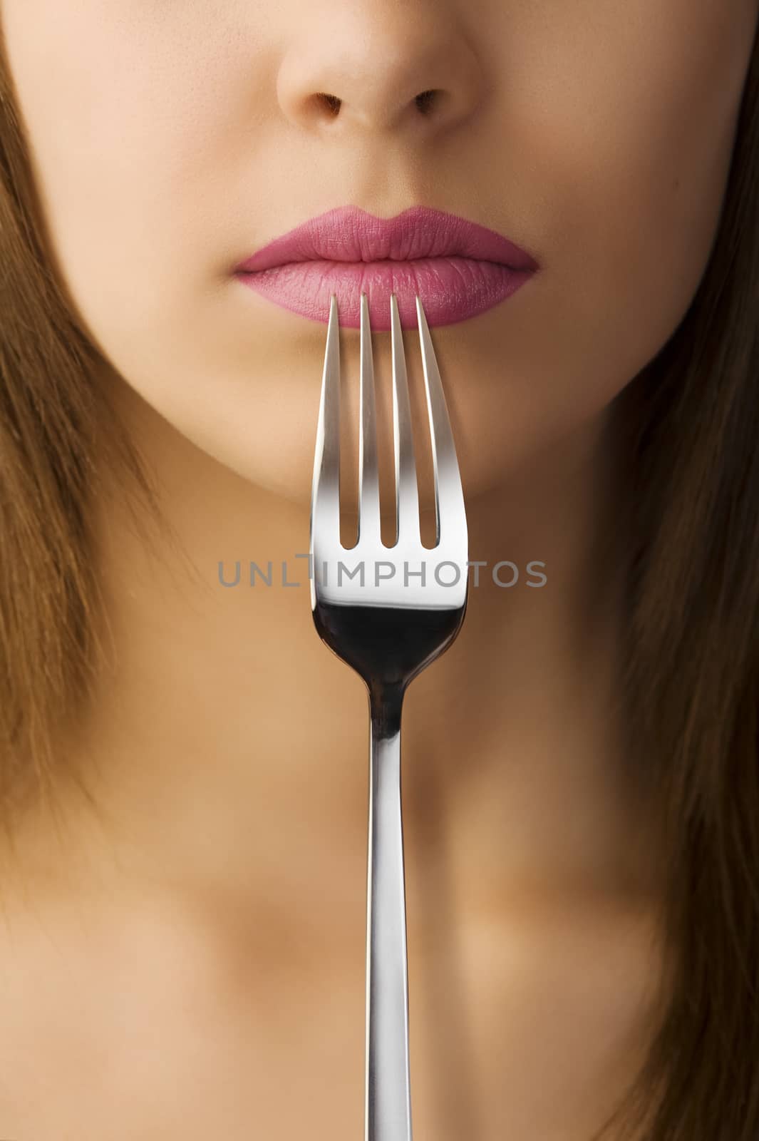 close up of woman mouth with pink lipstick keeping a fork near the lips