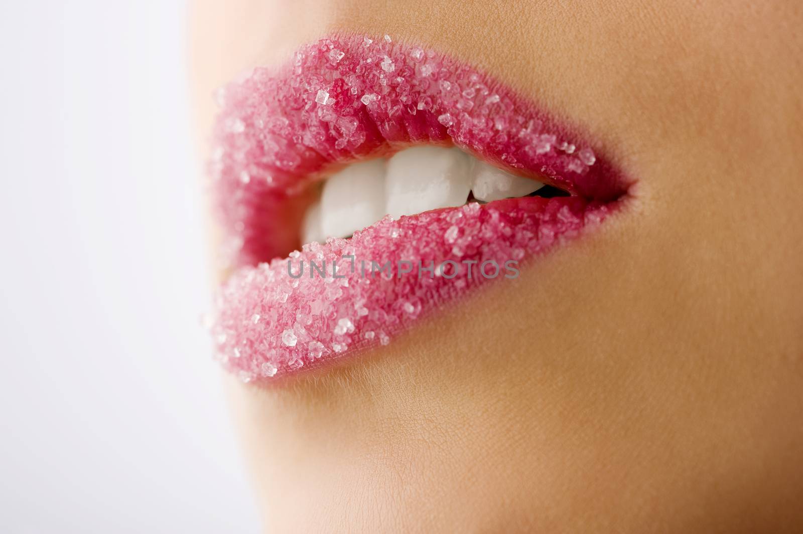 closeup on the woman mouth with some sugar on the lips
