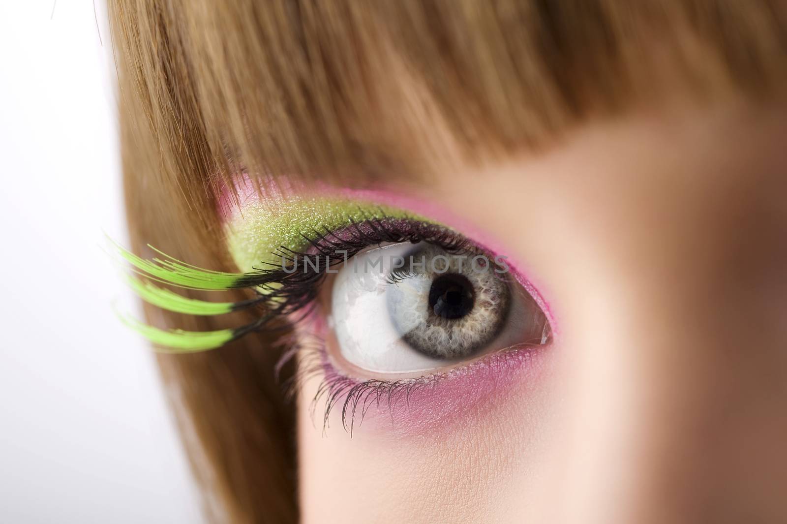 eye lloking in camera with colored make up and long eyelashes