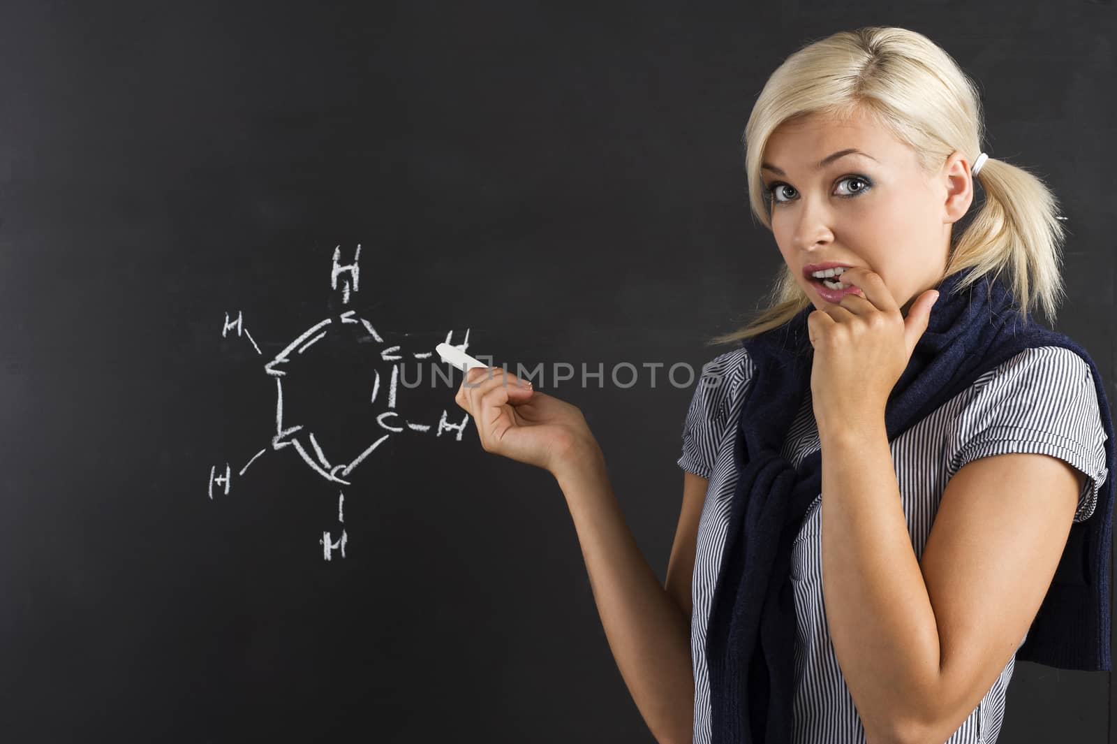 young beautiful student in front of the blackboard in act to be in trouble with the school lesson