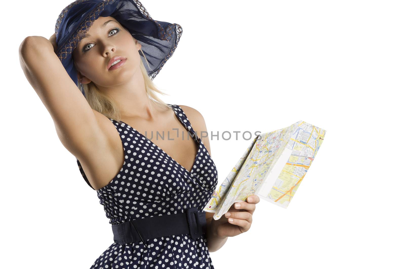 elegant woman in blue polka dot dress and hat looking at a tourist map