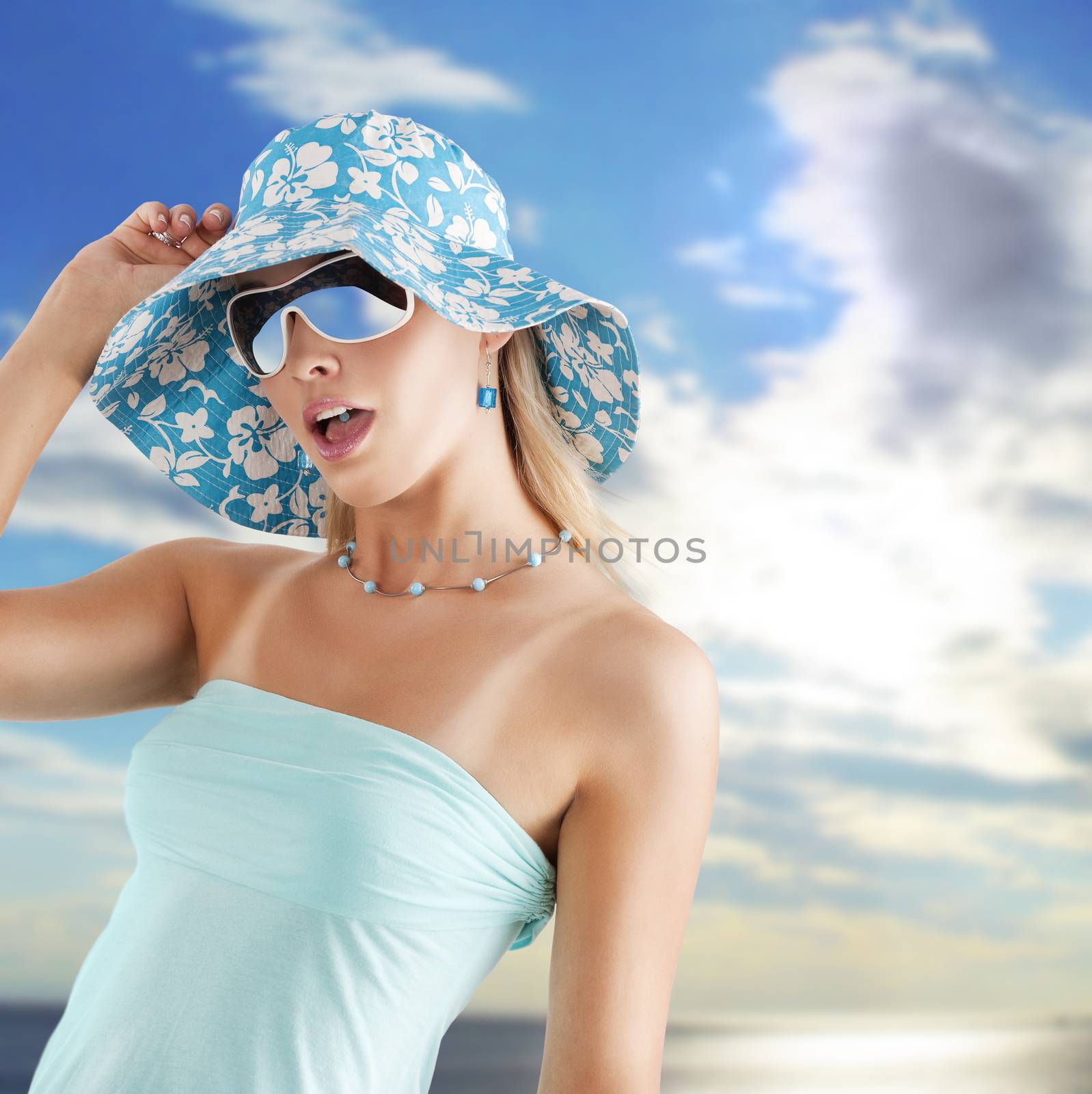 summer girl in light blue with hat and sunglasses in hot expression