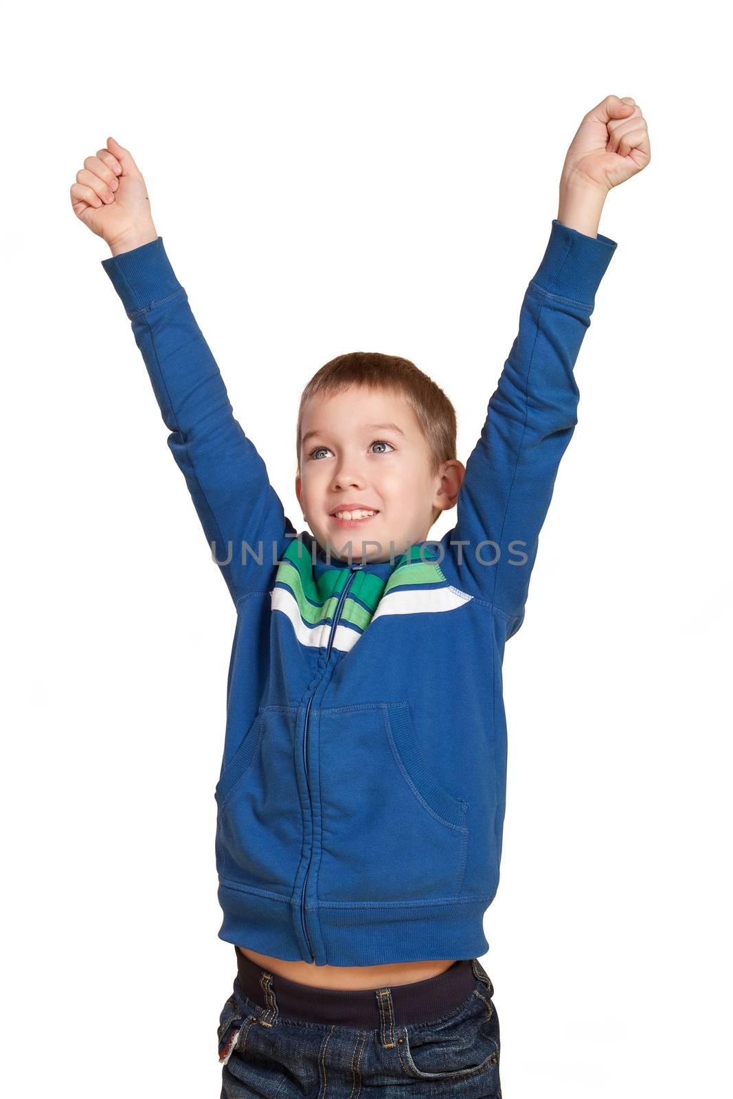 Young cute 10 year old white boy with hands in the air smiling expressing joy and victory. Expressions concept.