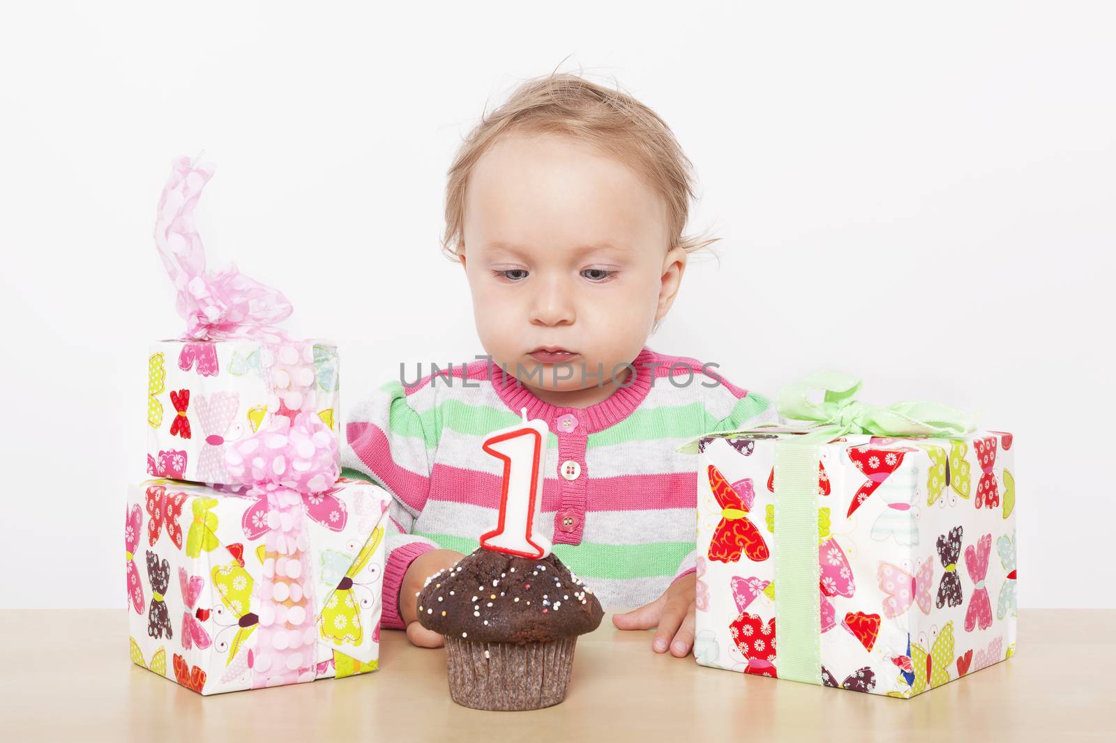 First birthday. Cute baby girl with birthday cake and birthday presents. 