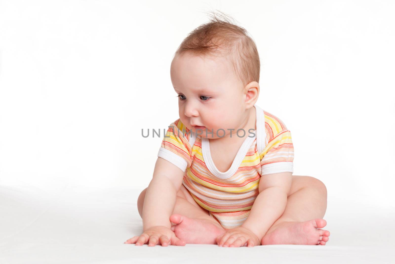 Cute small baby sitting and looking isolated on white background. Happy tiny adorable newborn baby.