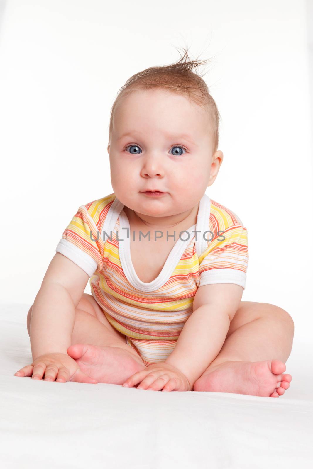 Cute caucasian baby girl sitting and looking into the camera isolated on white background. 
