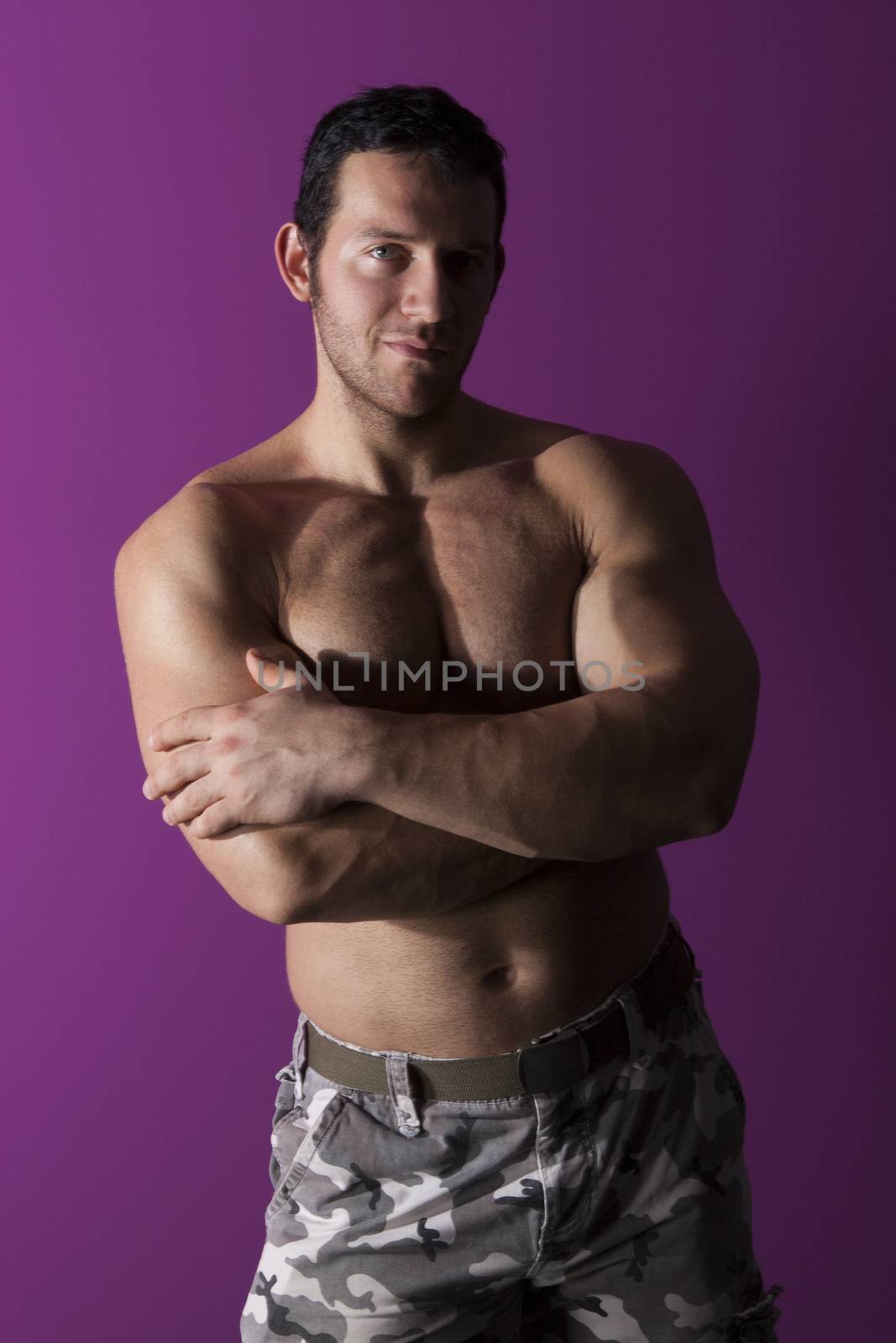 Sexy muscular shirtless bodybuilder smiling and looking into the camera isolated. Fitness is sexy.