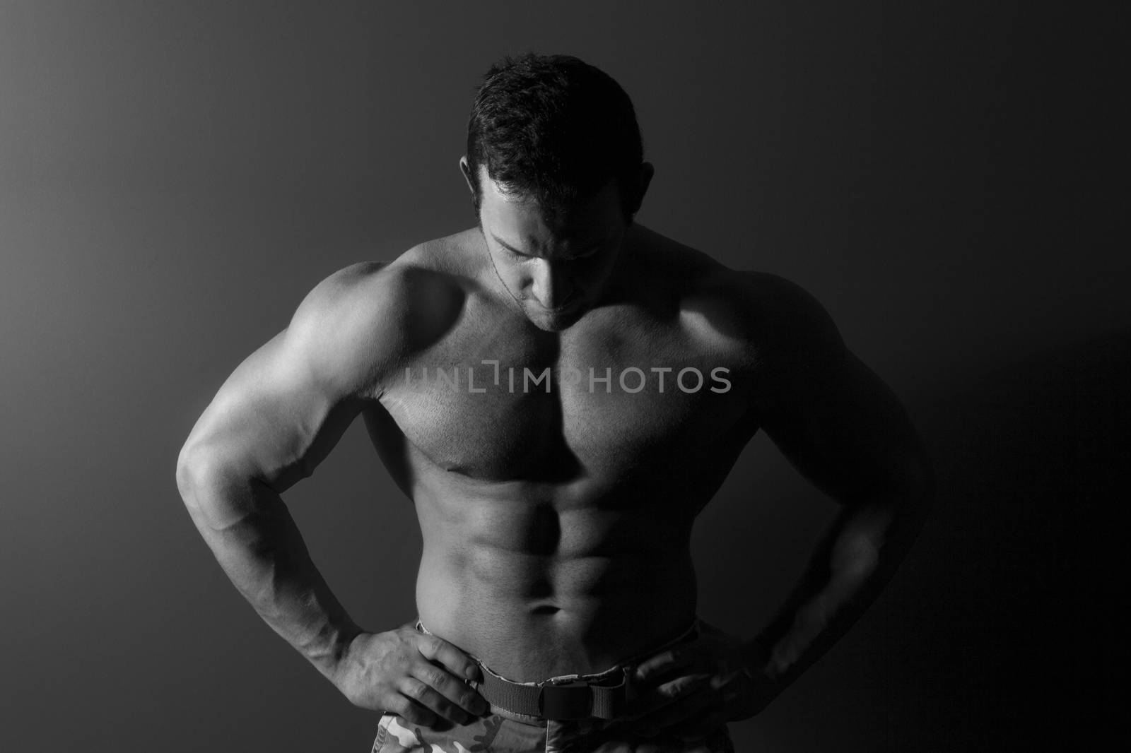 Sexy muscular bodybuilder isolated. Black and white fine art portrait.
