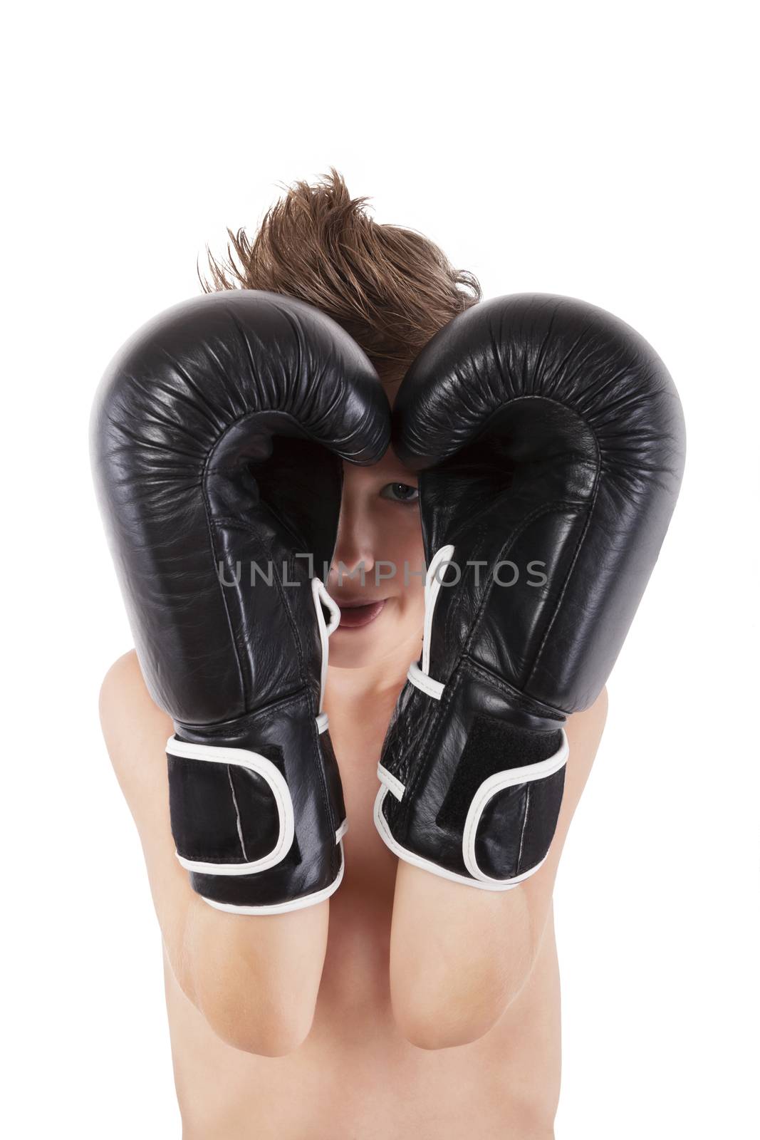 Young caucasian boy with boxing gloves protecting his face against white background. Small charming fighter. 