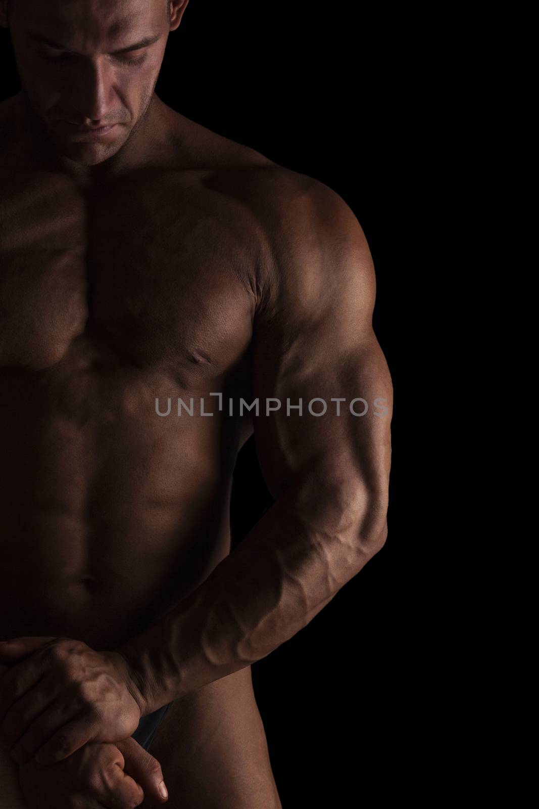 Sexy shirtless bodybuilder isolated on black background. Extreme strenght, muscles and fitness.