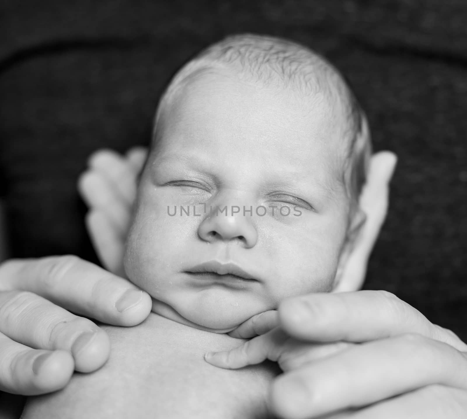 A Father hold newborn baby in his hands. Black-and-white photo
