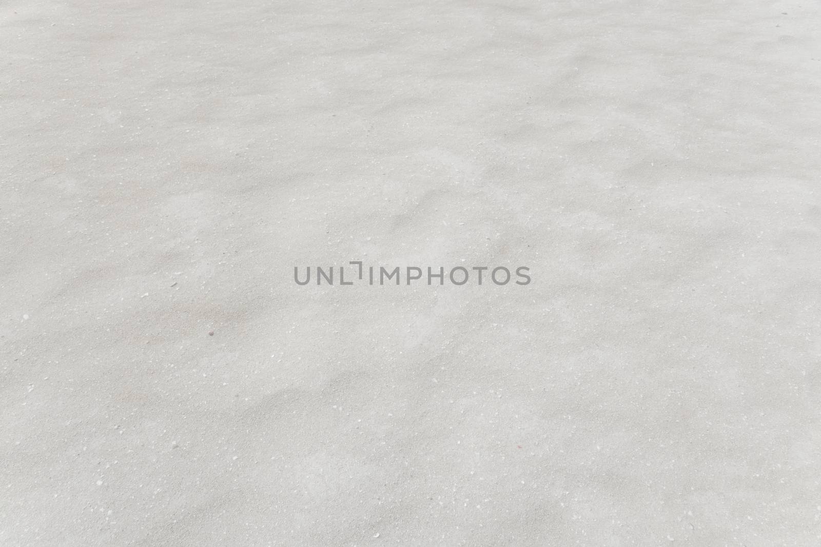 Wind blown sand creating little micro-dunes on a beach. Texture background.