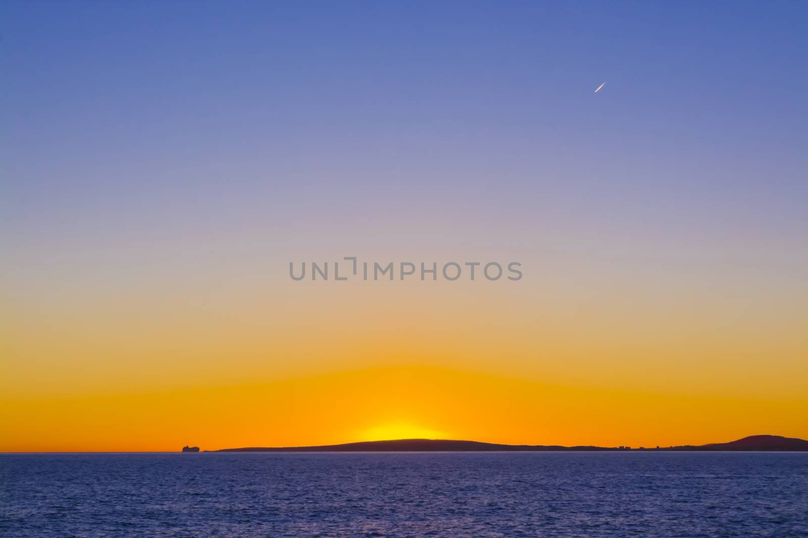 Colorful Sunset Traffic. Sunset view in blue and yellow with airplane and ferry traffic. Palma bay, Mallorca, Balearic islands, Spain.