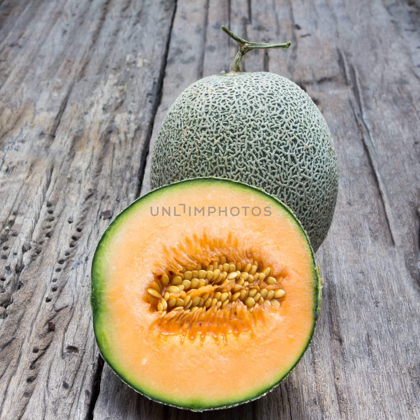 cantaloupe melon slices on old wood background