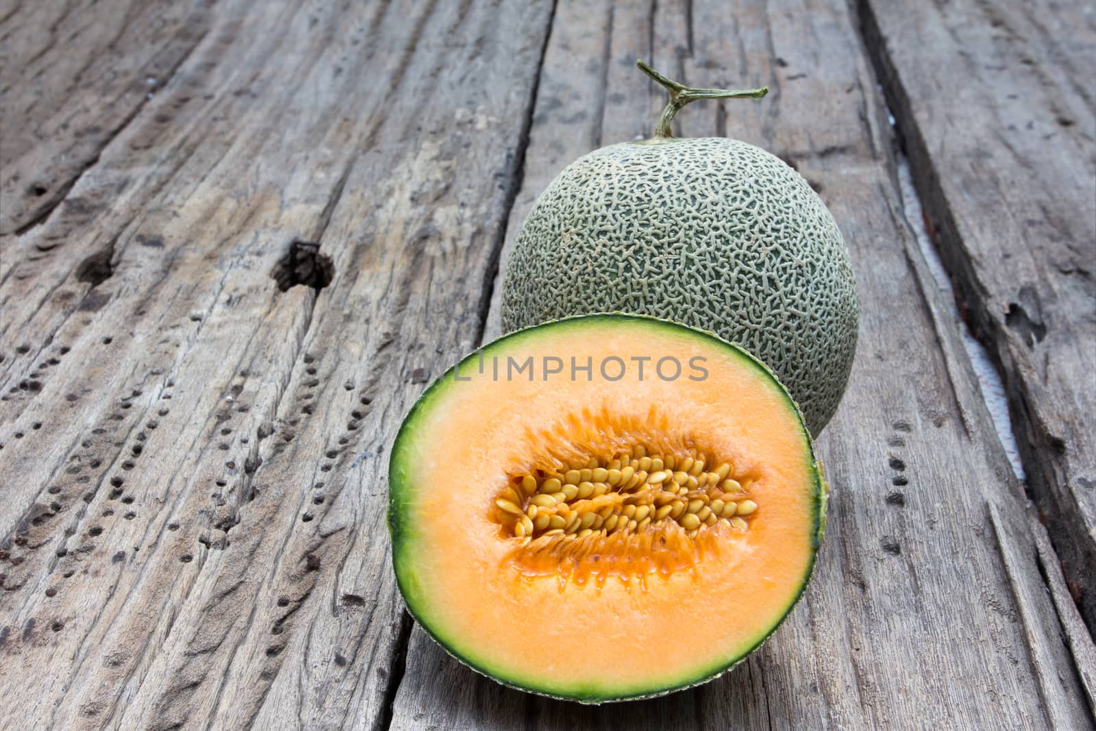 cantaloupe melon slices on old wood background