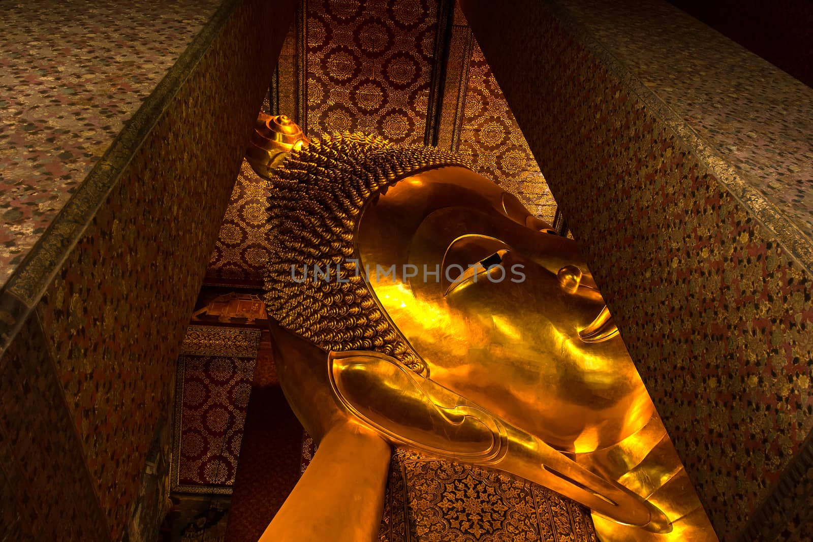 Reclining Buddha gold statue face. Wat Pho, Bangkok, Thailand by kannapon