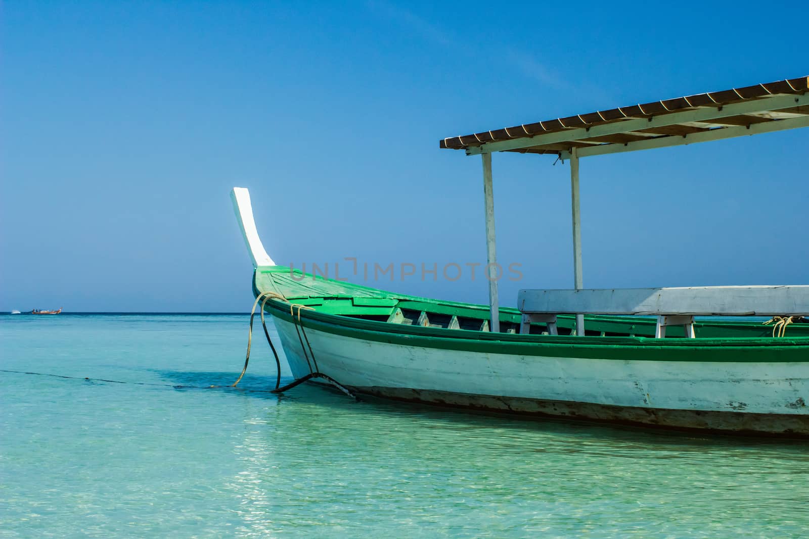 Beautiful small fishing wooden boat located in blue sea and sky