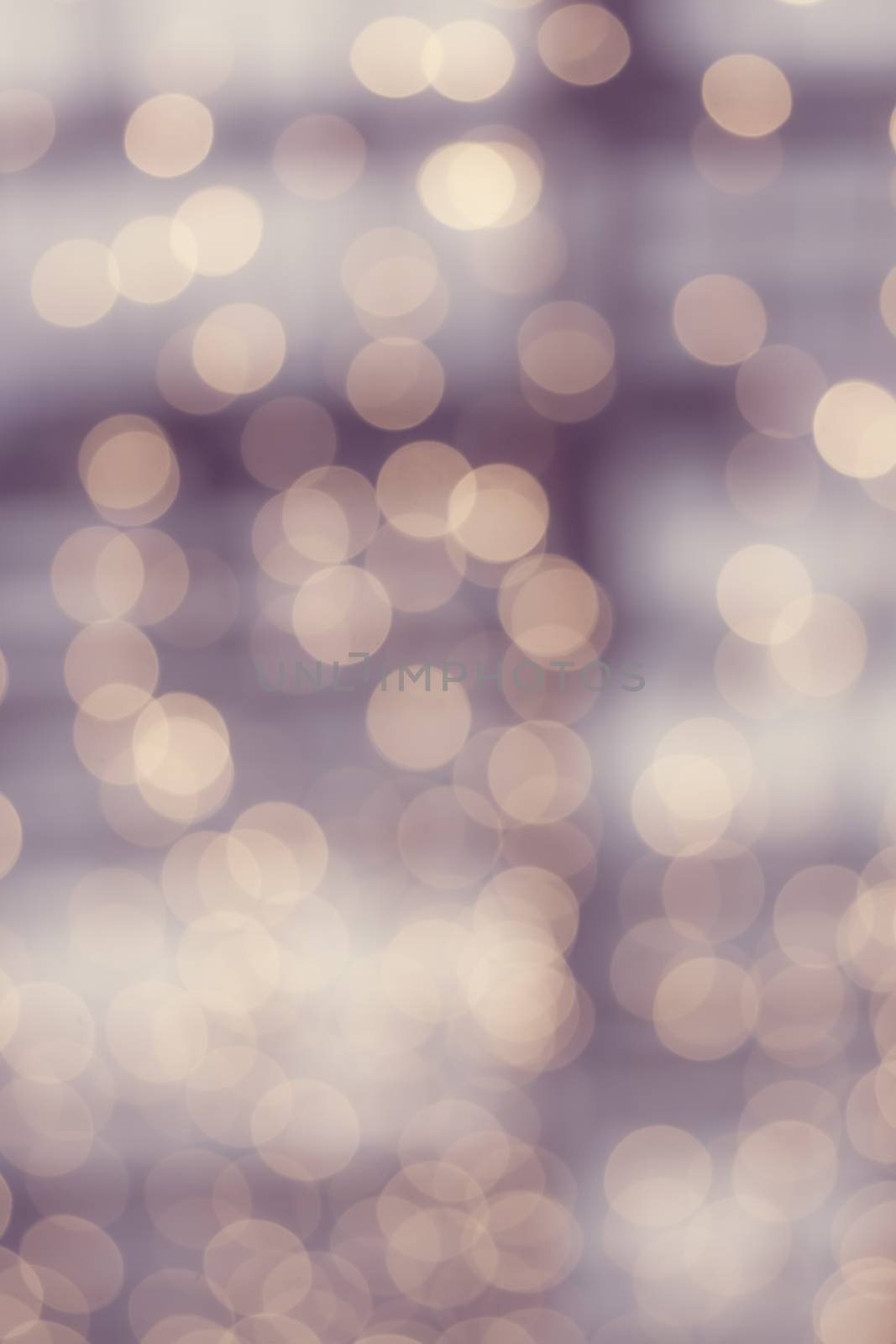 Blurry lights background vertical in soft violet and nude bokeh tones.