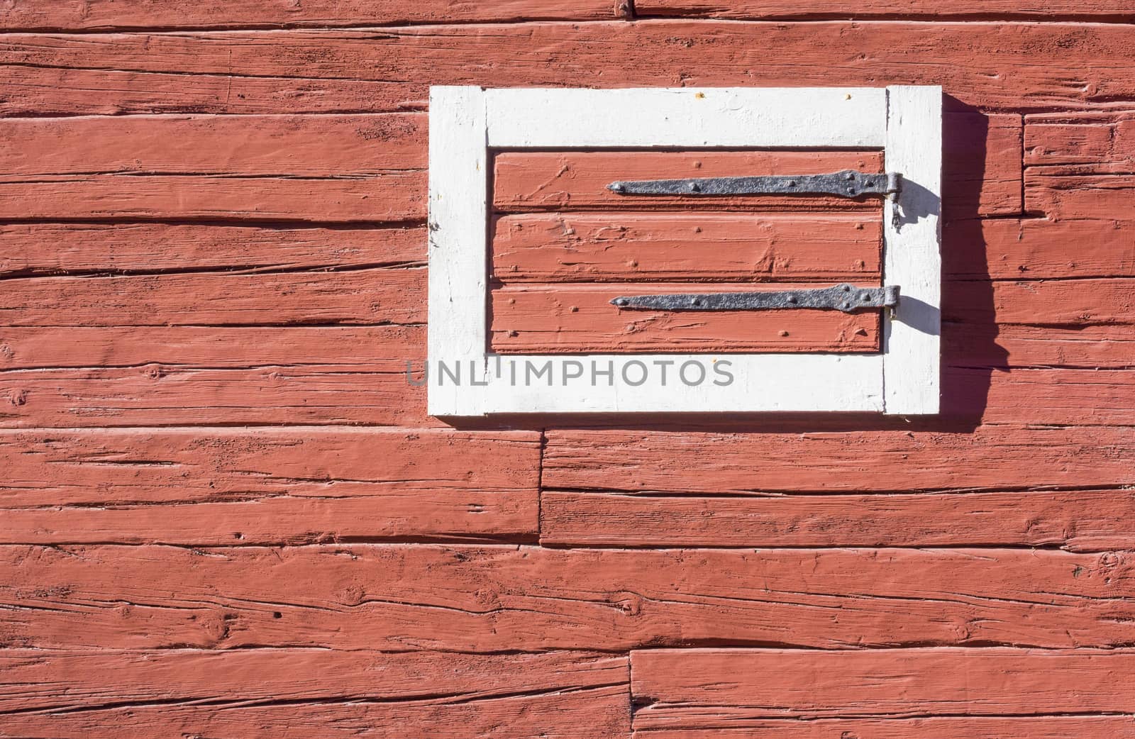 Red Log House Wall with Hatch. Detail of traditional Swedish red painted log house with white painted trimmings around the hatch. Stockholm, Sweden.