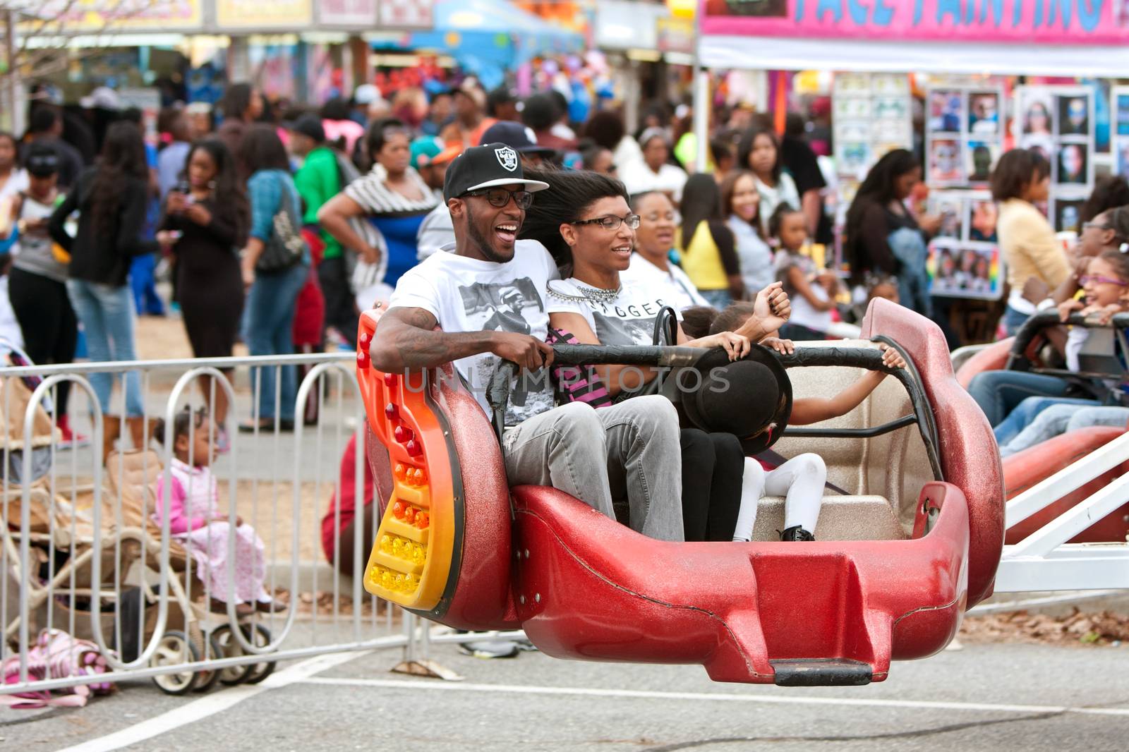 Atlanta, GA, USA - March 15, 2014:  A family laughs while riding a fast-moving carnival ride at the annual Atlanta Fair.