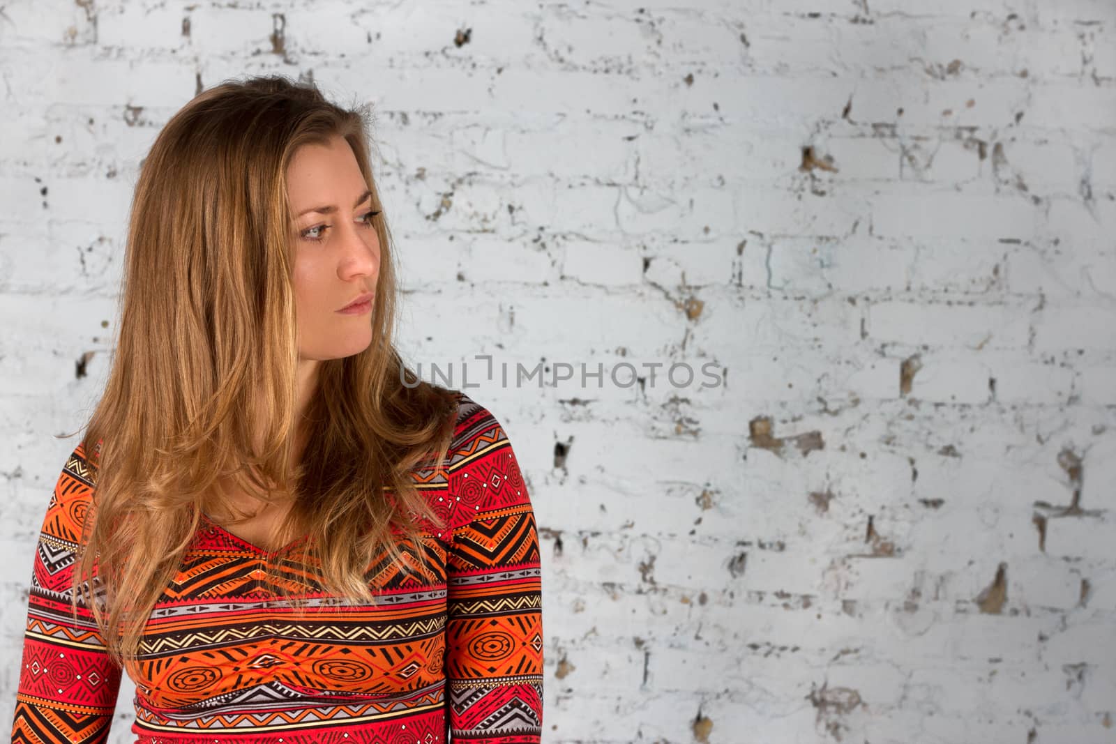 Girl in a blue shirt against a background of  brick wall