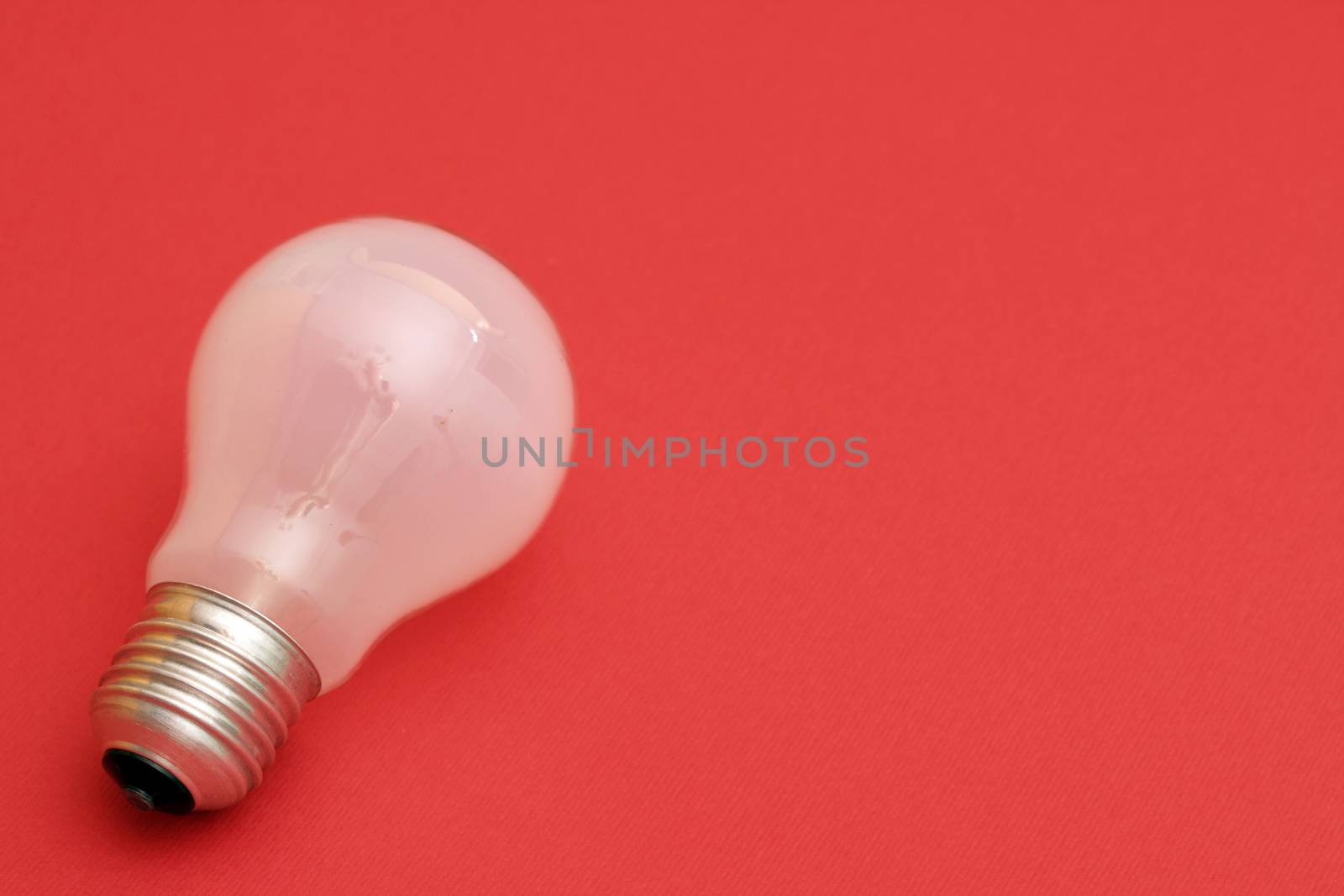 Background with lit lightbulb. Isolated on red