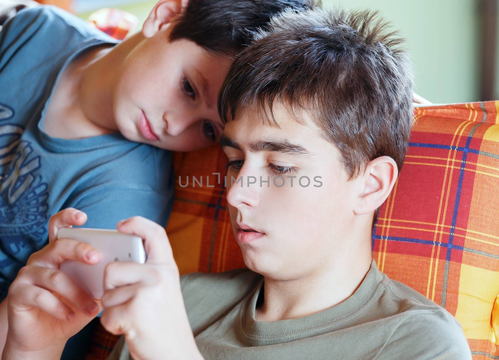 Teenager boys playing on smartphone, outdoor with shallow focus