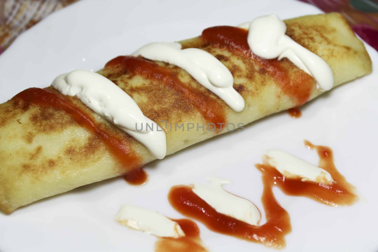 Crepes with cream sauce and ketchup.