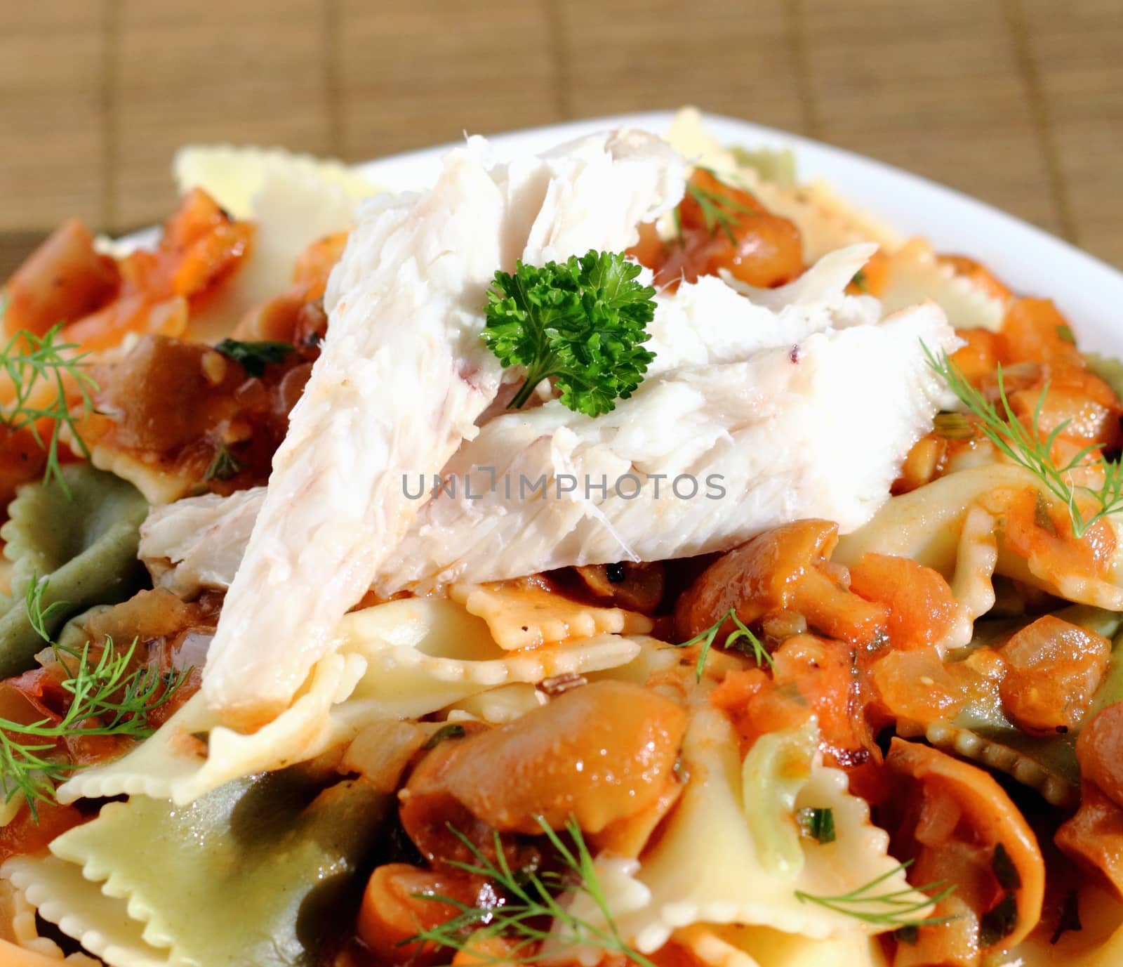 Smoked fish fillet served with pasta and sauce with mushrooms